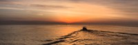 A sunrise by the sea with a fishing boat